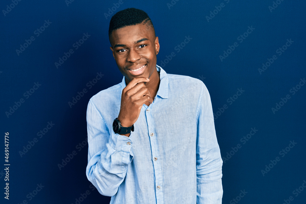 Young african american man wearing casual clothes looking confident at the camera with smile with crossed arms and hand raised on chin. thinking positive.
