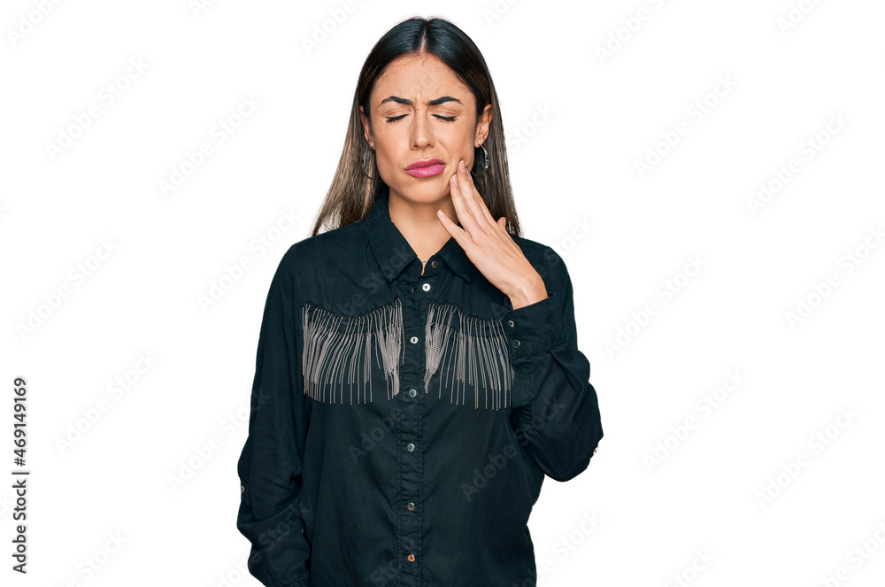 Young hispanic woman wearing casual clothes touching mouth with hand with painful expression because of toothache or dental illness on teeth. dentist Young hispanic woman wearing casual clothes touching mouth with hand with painful expression because of toothache or dental illness on teeth. dentist