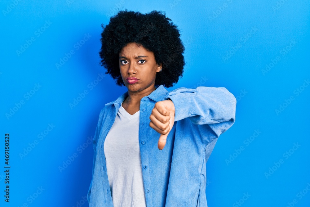 Young african american woman wearing casual clothes looking unhappy and angry showing rejection and negative with thumbs down gesture. bad expression. Young african american woman wearing casual clothes looking unhappy and angry showing rejection and negative with thumbs down gesture. bad expression.