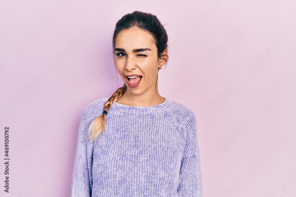 Fototapeta premium Young hispanic girl wearing casual clothes winking looking at the camera with sexy expression, cheerful and happy face.