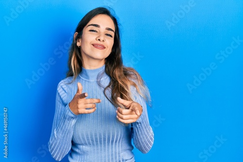 Young hispanic girl wearing casual clothes pointing fingers to camera with happy and funny face. good energy and vibes.