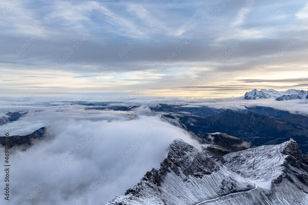 View from the summit of mountain Schilthorn in the Swiss Alps Switzerland at sunrise with dramatic clouds and fresh snow. View from the summit of mountain Schilthorn in the Swiss Alps Switzerland at sunrise with dramatic clouds and fresh snow.