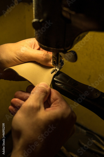 Arbeiten eines Schuhmachers an der Nähmaschine und mir Leder
