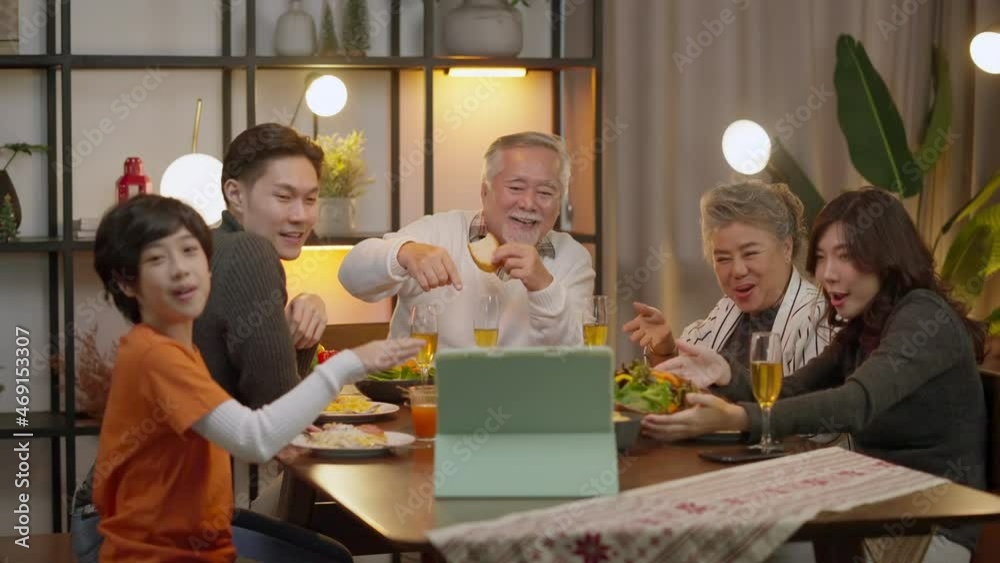 happiness asian multi generation have dinner together while video calling conference to distance relative friend using tablet device wireless internet connection,family waving hand to tablet say hi happiness asian multi generation have dinner together while video calling conference to distance relative friend using tablet device wireless internet connection,family waving hand to tablet say hi