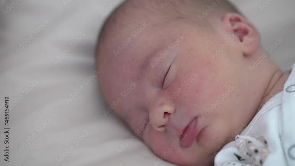 Adorable infant sleeps calm on soft bed at home. Facial portrait of a baby boy sleeping. Healthy dream. Quiet night for parents after childbirth. Adorable infant sleeps calm on soft bed at home. Facial portrait of a baby boy sleeping. Healthy dream. Quiet night for parents after childbirth.