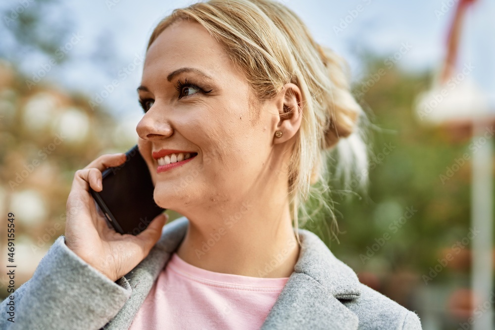 Young blonde businesswoman smiling happy talking on the smartphone at the city. Young blonde businesswoman smiling happy talking on the smartphone at the city.