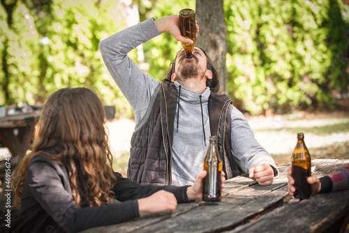 Obraz na plátně Friends chugging bottle beer. Express drinking and fast get drunk