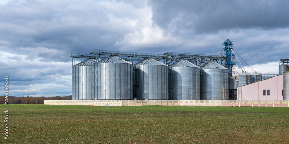 modern granary elevator and seed cleaning line in silver silos on agro-processing and manufacturing plant for storage and processing drying cleaning of agricultural products, flour, cereals and grain