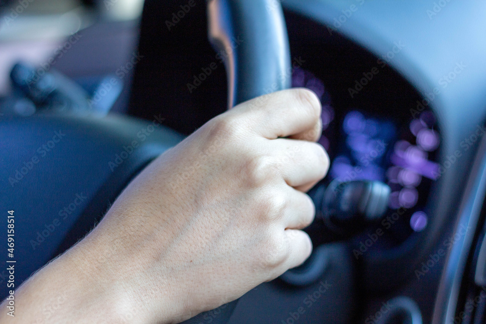Hand holding car steering wheel. selective focus