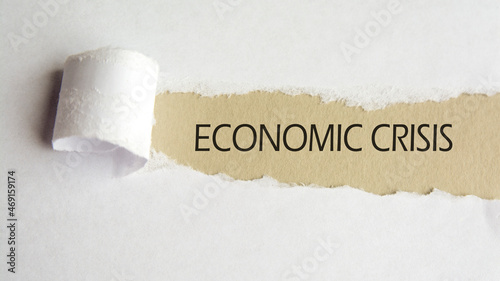 economic crisis. text on brown paper under a torn white paper sheet, business concept