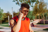 athletic man talking on the phone in the park