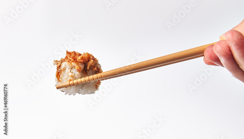  Chopsticks holding single uramaki sushi isolated on white background