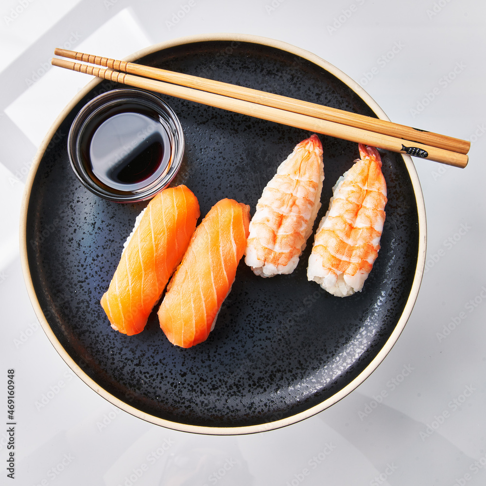 Plate of two shrimp nigiri sushi and two salomon nigiri sushi isolated on  white background Stock Photo | Adobe Stock