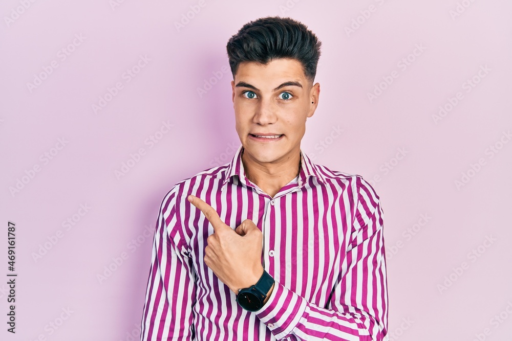 Young hispanic man wearing casual clothes pointing aside worried and nervous with forefinger, concerned and surprised expression Young hispanic man wearing casual clothes pointing aside worried and nervous with forefinger, concerned and surprised expression