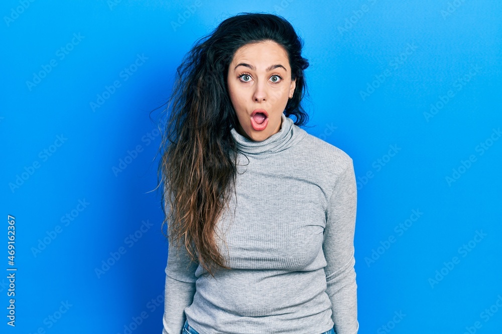 Fototapeta premium Young hispanic woman wearing casual clothes scared and amazed with open mouth for surprise, disbelief face