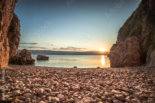 Fototapeta Naklejka Na Ścianę i Meble -  Hidden beach in Vrbnik on the island of Krk in Croatia. Beautiful stone beach between rocks and taken at sunrise.