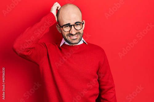 Young bald man wearing casual clothes and glasses confuse and wonder about question. uncertain with doubt, thinking with hand on head. pensive concept. © Krakenimages.com