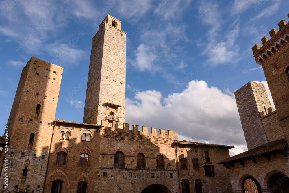 Geschlechtertürme in San Gimignano, Toskana,  bei Himmel und Wolken mit Sonnenschien