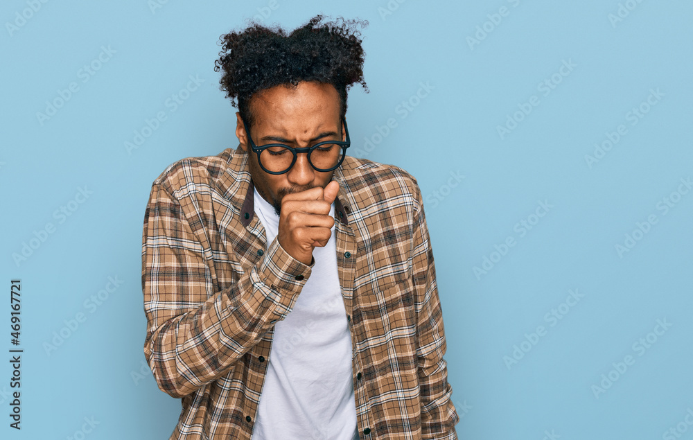Young african american man with beard wearing casual clothes and glasses feeling unwell and coughing as symptom for cold or bronchitis. health care concept. Young african american man with beard wearing casual clothes and glasses feeling unwell and coughing as symptom for cold or bronchitis. health care concept.