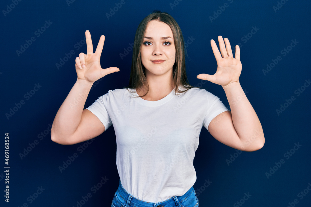 Young hispanic girl wearing casual white t shirt showing and pointing up with fingers number eight while smiling confident and happy.