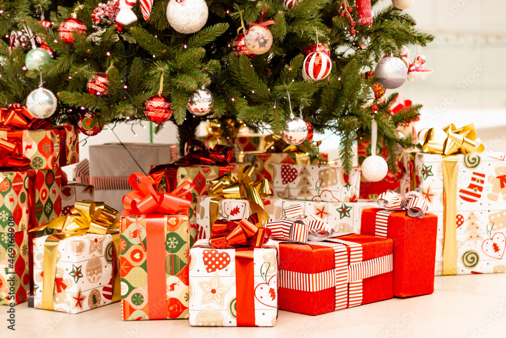 Christmas gifts under the tree. New Year's and Christmas. Wrapped gift. Beautiful packaging. Ribbon and bow on the package.