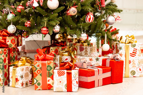 Obraz na płótnie Christmas gifts under the tree. New Year's and Christmas. Wrapped gift. Beautiful packaging. Ribbon and bow on the package. w salonie