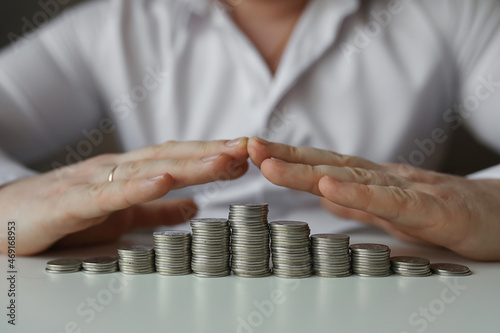 person holding hands above coins