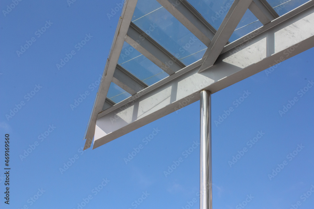 Triangular glass roof cut out against the blue sky