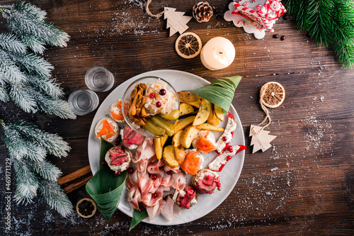 Fototapeta Naklejka Na Ścianę i Meble -  christmas antipasti dry cured meat on a plate on a table with fir tree