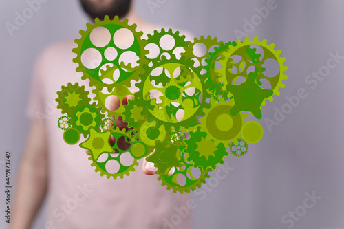 Mechanism, green metallic gears and cogs at work on brown background. Industrial machinery. 3D