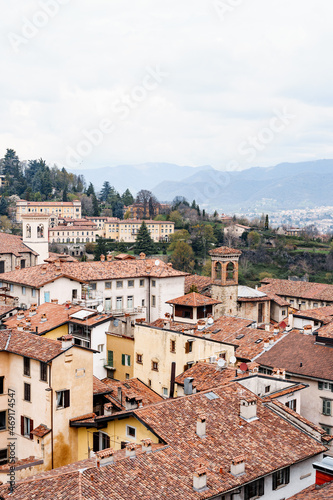 Tiled roofs of the old houses of Bergamo against the backdrop of the mountains. Italy