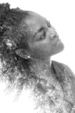 A black and white portrait of an African American woman combined with foliage in a double exposure technique.