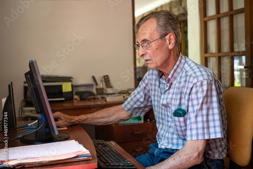 Older man very concentrated in front of computer at home,