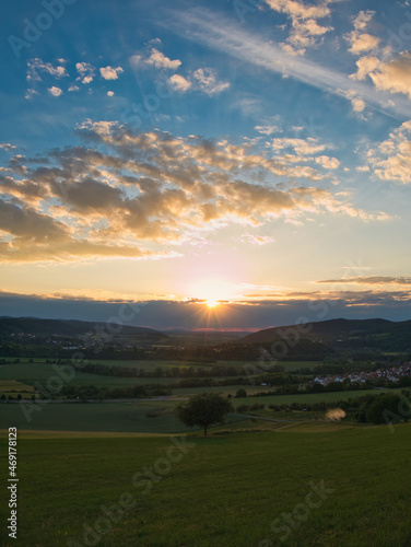 Sonnenuntergang mit schöner Landschaft aus Nordhessen im Vordergrund.