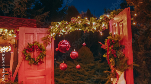 Beautiful house decorated for Christmas is about Christmas trees. Open the door of the house for Santa Claus. Christmas night. Christmas holiday wreath adorns front door to home. photo