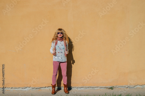 middle aged woman on isolated street wall © carballo