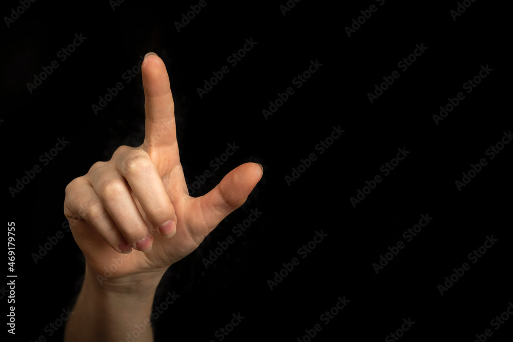 Businesswoman hand pointing on empty space on a black background photo Businesswoman hand pointing on empty space on a black background photo