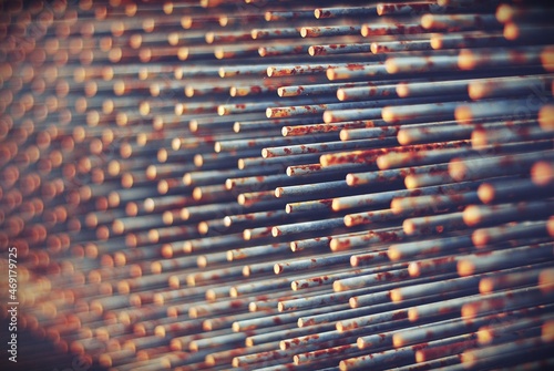Industrialna abstrakcja przedstawiająca długie, metalowe, pordzewiałe pręty krat