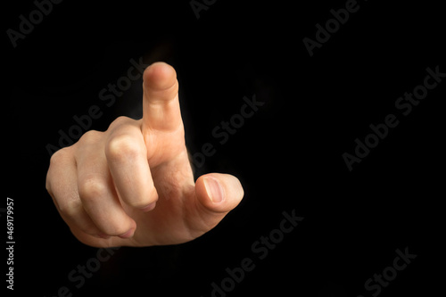 Hand pointing gesture on empty space on a black background photo