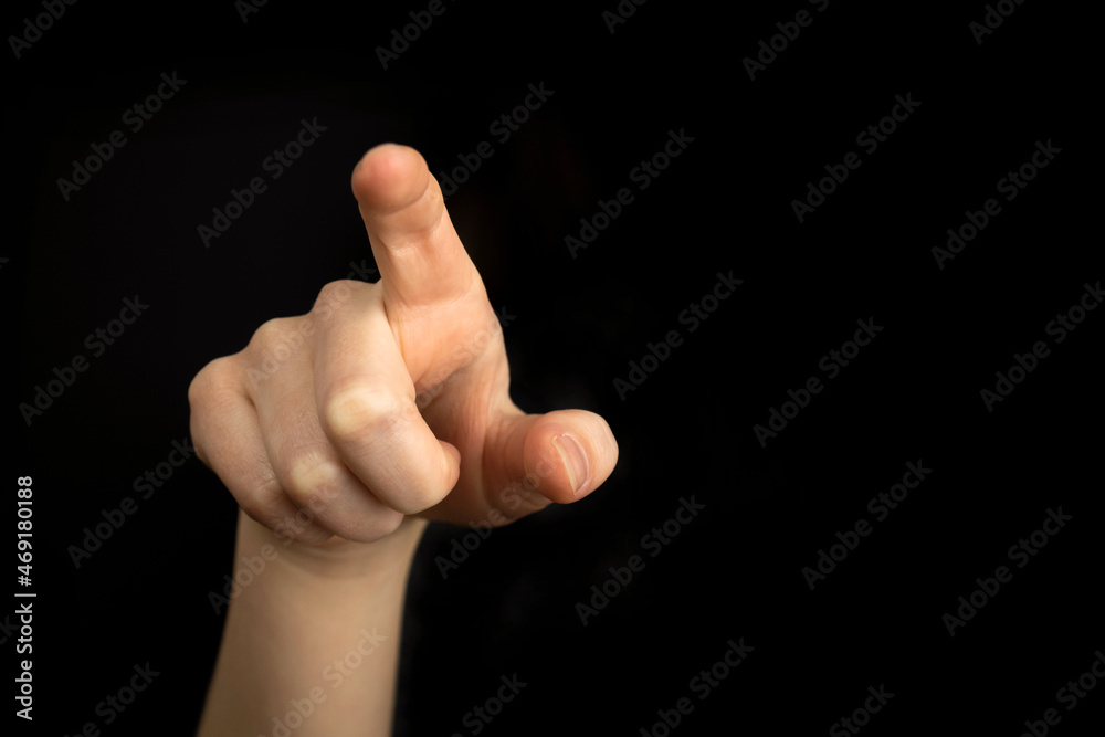Hand pointing gesture on empty space on a black background Hand pointing gesture on empty space on a black background