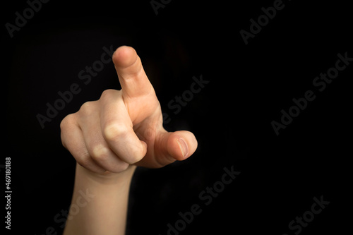 Hand pointing gesture on empty space on a black background