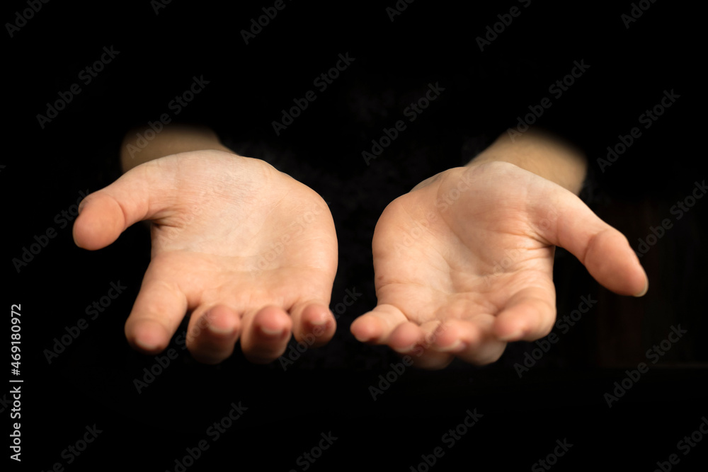 Empty hands with empty palms up isolated on a black background Empty hands with empty palms up isolated on a black background