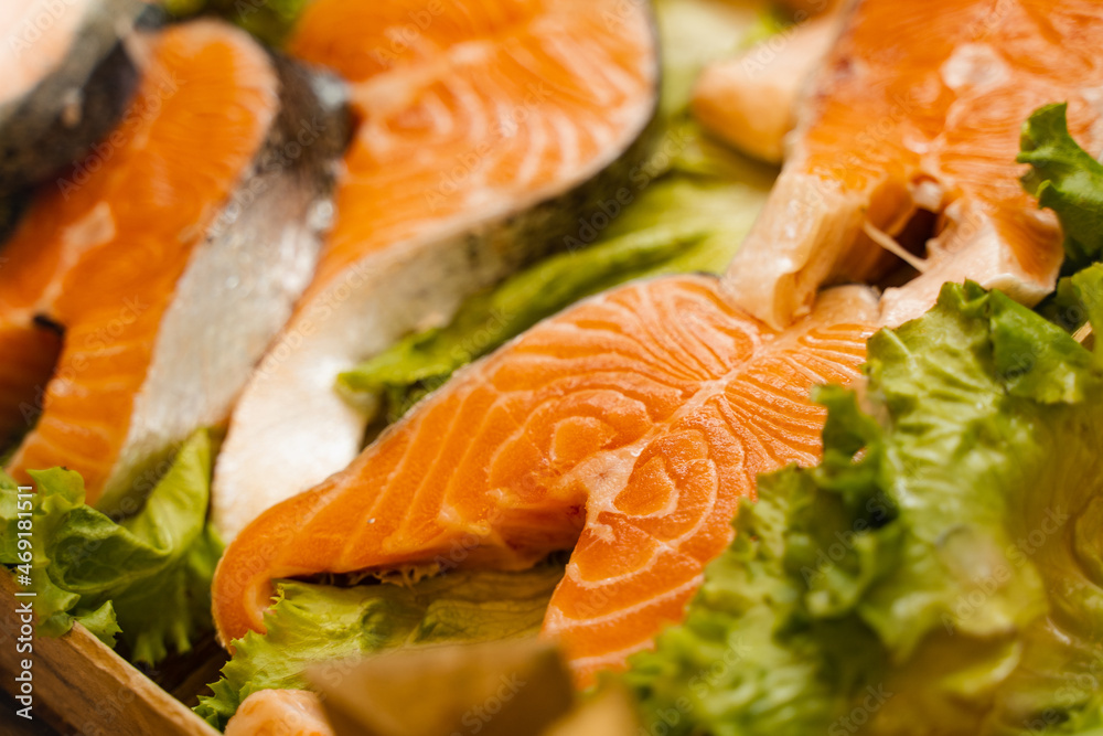 Salmon steaks with lettuce close-up. Fresh raw red fish. Salmon steaks with lettuce close-up. Fresh raw red fish.