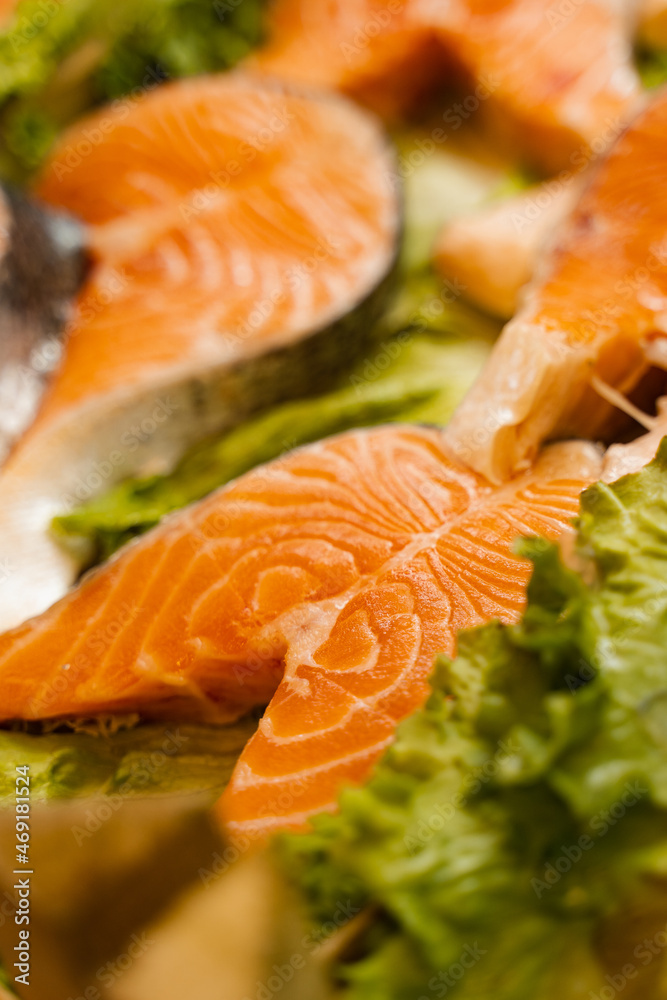 Salmon steaks with lettuce close-up. Fresh raw red fish.
