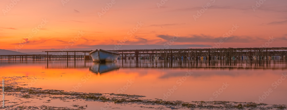 Fototapeta premium Vue d'un coucher de soleil sur les parcs à moules d'un étang de la Camargue, réserve naturelle protégée