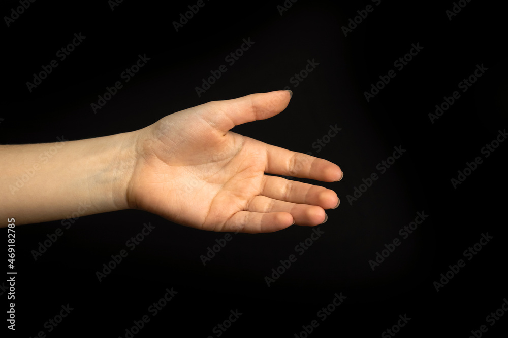 Young woman ready for handshake gesture on a black background. Business and professional teamwork concept photo Young woman ready for handshake gesture on a black background. Business and professional teamwork concept photo