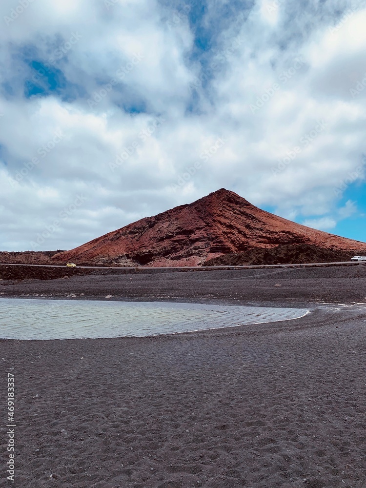 Black beach with a red volcano