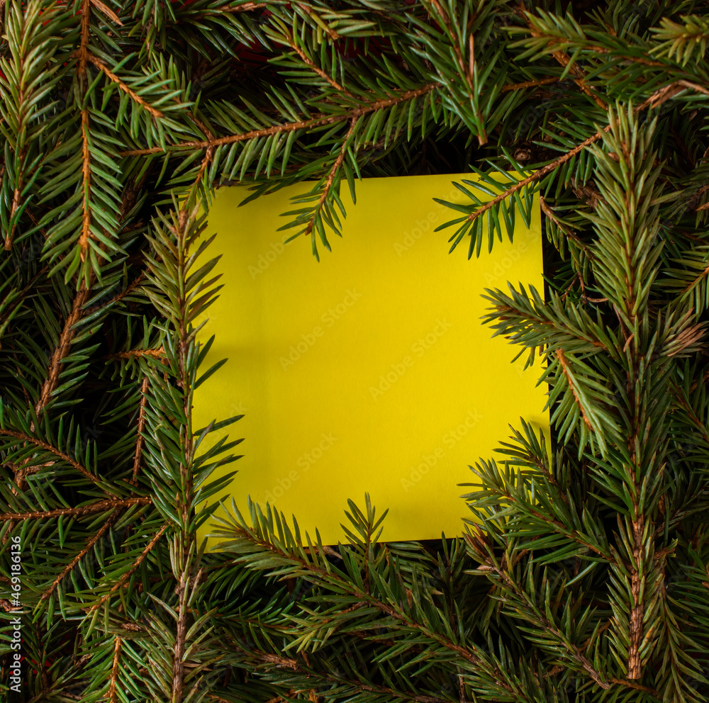 a yellow sticker is placed inside the branches of the Christmas tree. space for text. top view.
