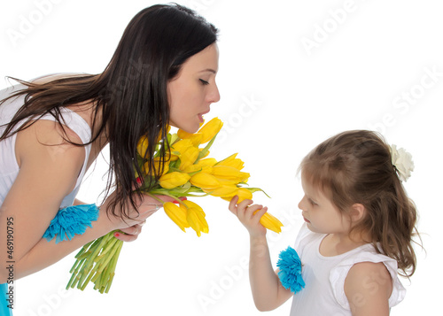 Mom and daughter enjoying the fragrance of flowers.