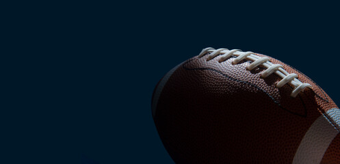 American football ball close up on dark background. Horizontal sport theme poster, greeting cards, headers, website and app